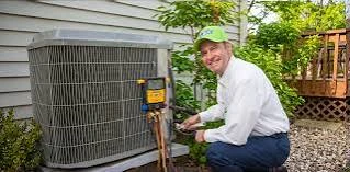 Service technician checking an outdoor condenser beside a home